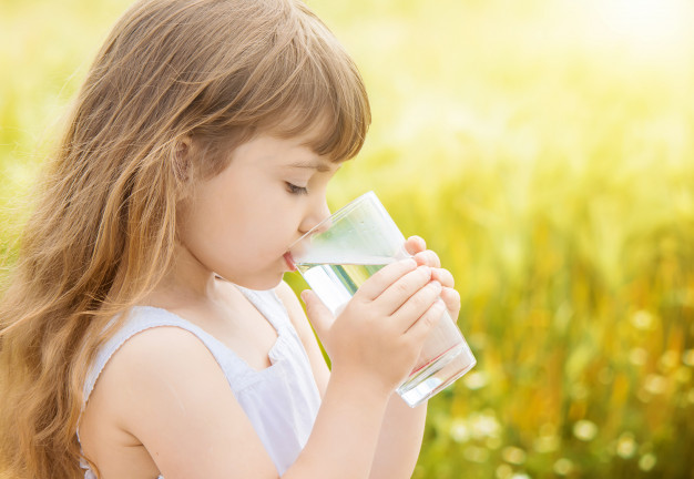 bambina che beve acqua trattata in un campo di grano 2